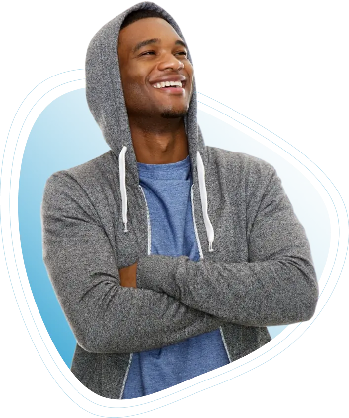 A happy young man with arms folded, smiling with pride in his decision to donate plasma